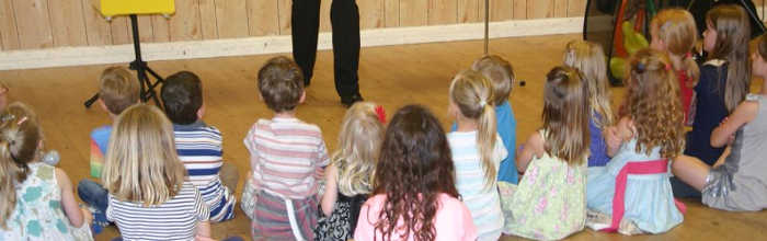 Enfants assis en train de regarder le magicien